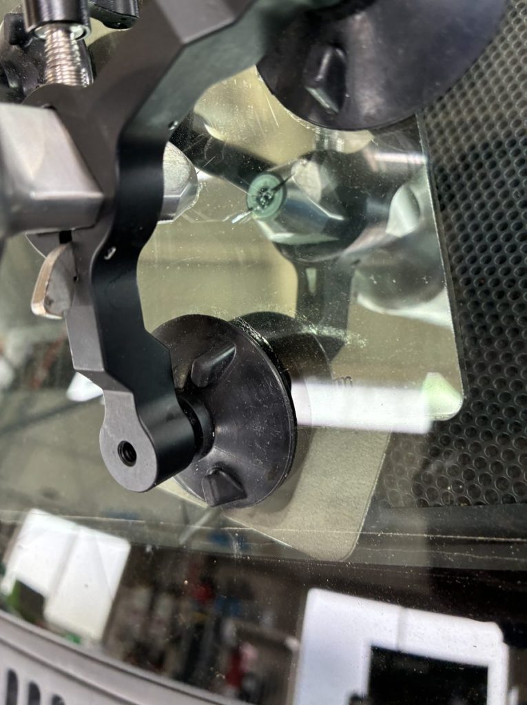 フロントガラス下部の難易度が高い箇所に専用リペア機材をセットして施工中