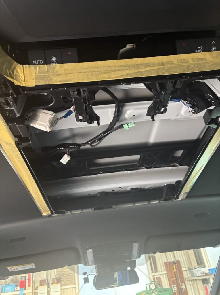 新車の40アルファードの天井をカットし、純正モニター用の配線と金具をインストール中